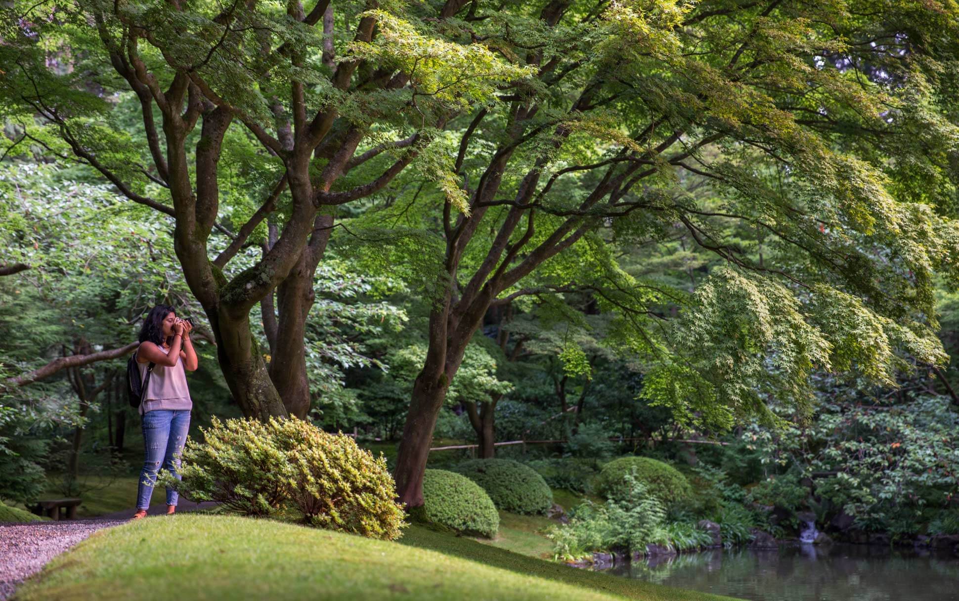 A tourist takes photos in UBC's Nitobe Memorial Garden.