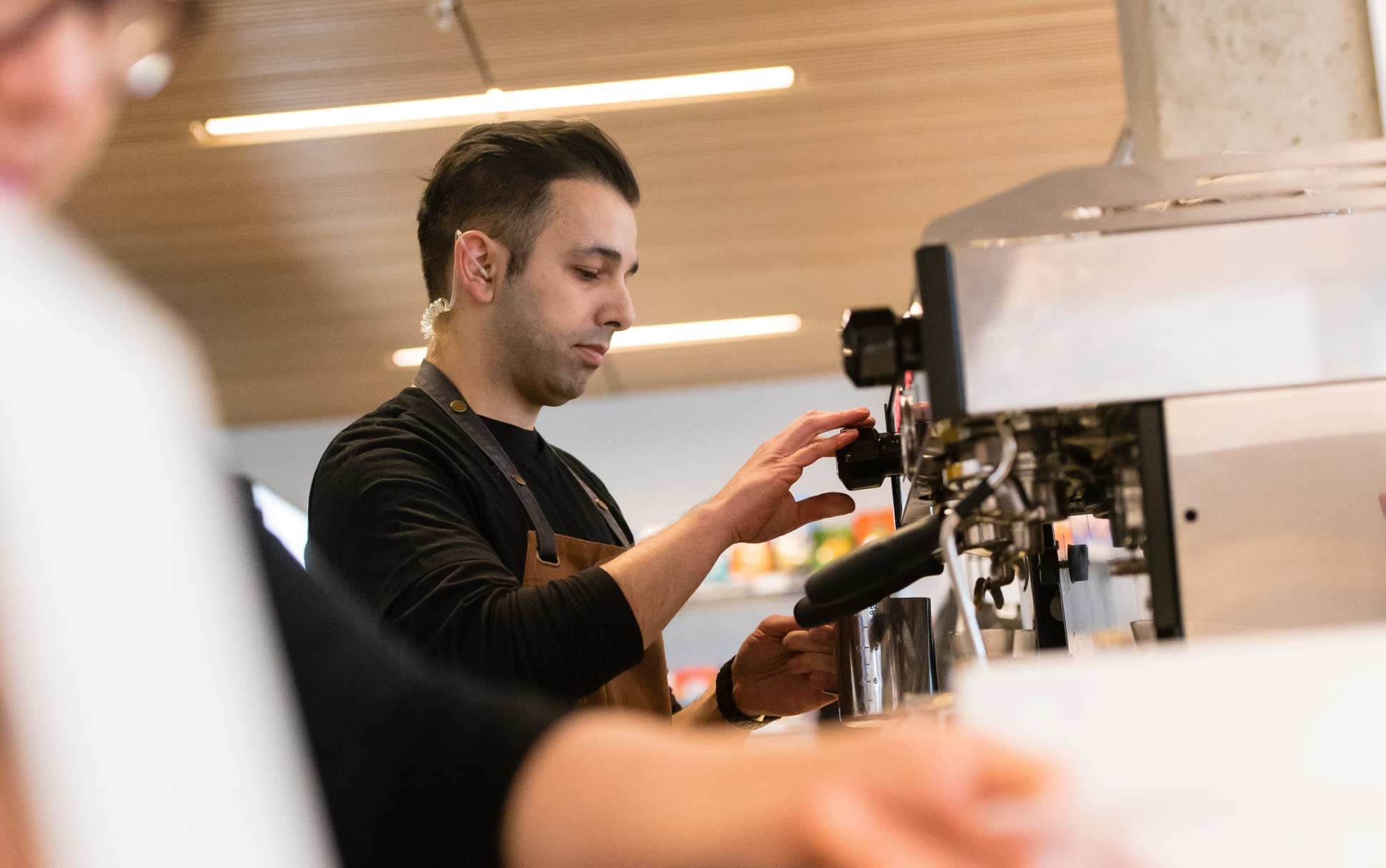 A barista prepares coffee at a UBC Vancouver café.