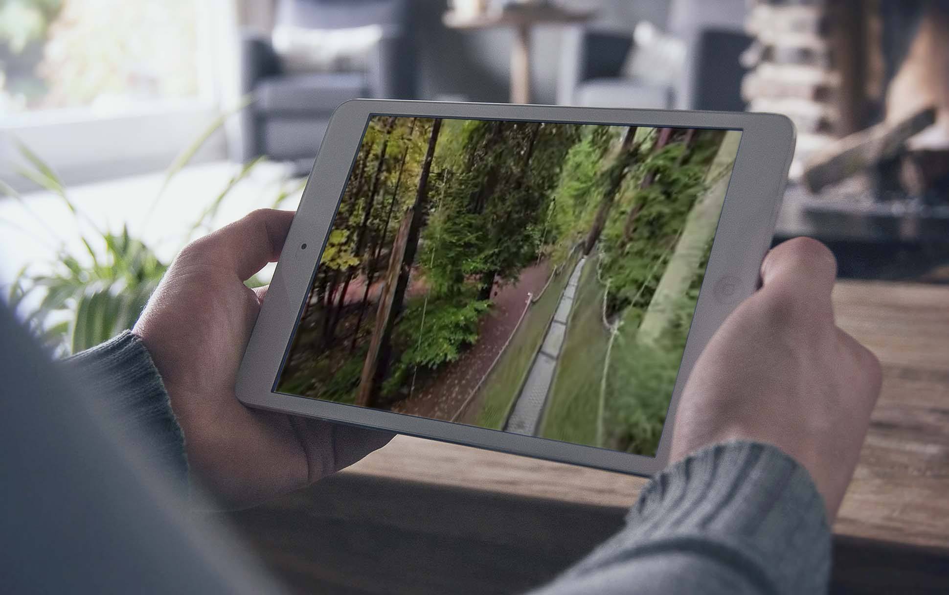 A person watches a virtual tour of the UBC Botanical Garden on their tablet.